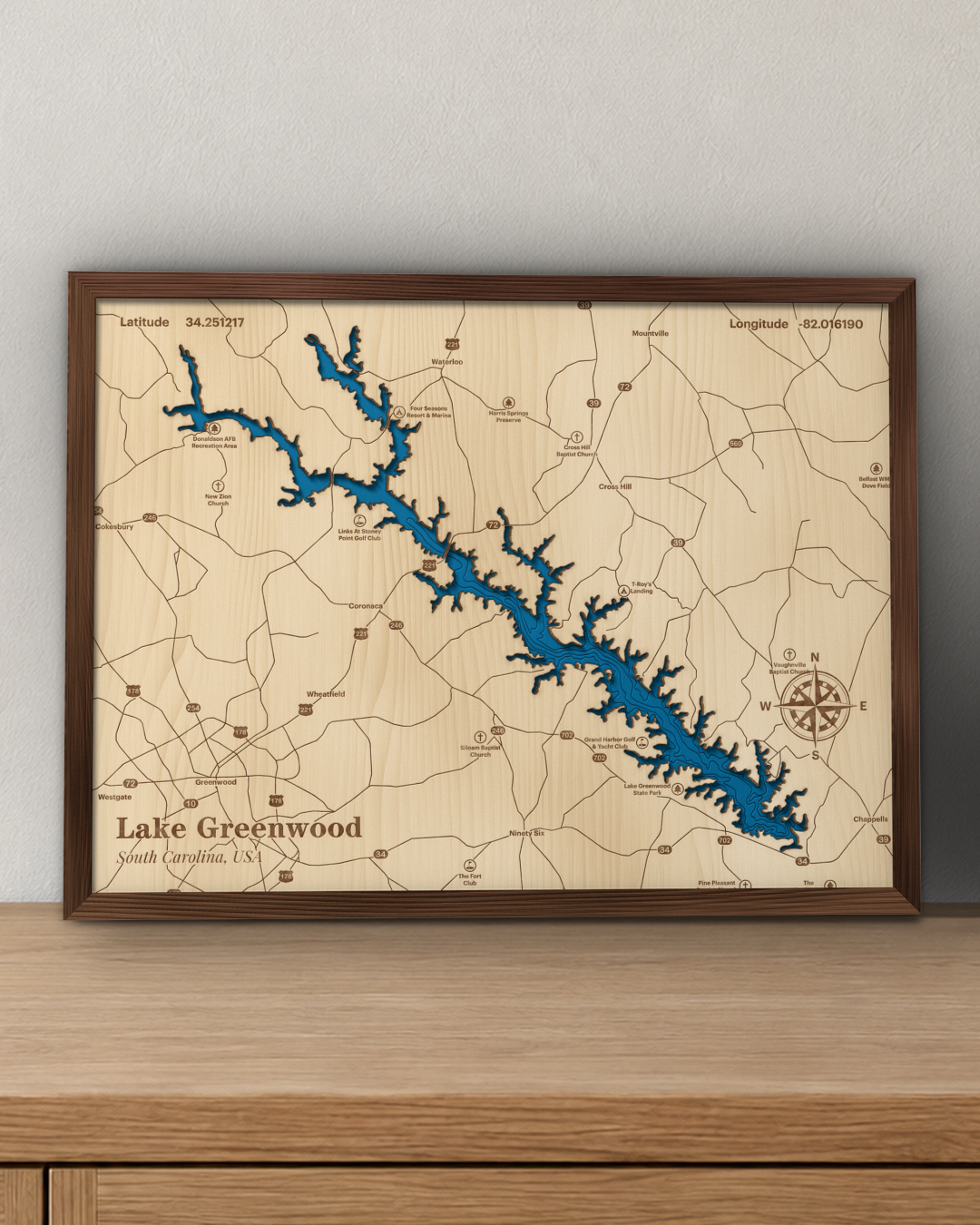 Lake Greenwood wood map in a walnut frame standing on a wooden sideboard against a wall for scale