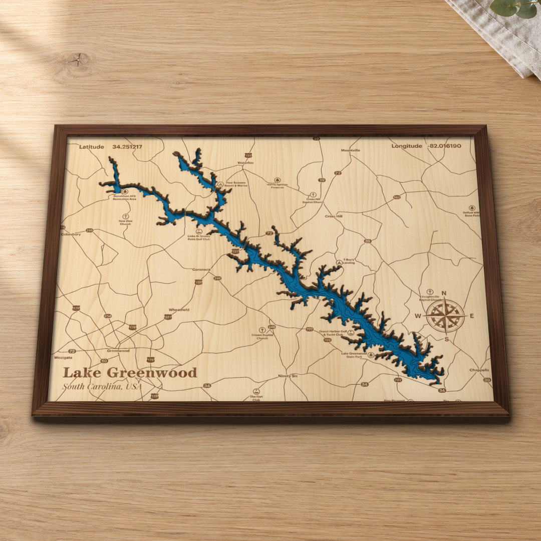 Lake Greenwood wood map lying flat on a wooden tabletop, showing the depth contours and every cove of the lake engraved in