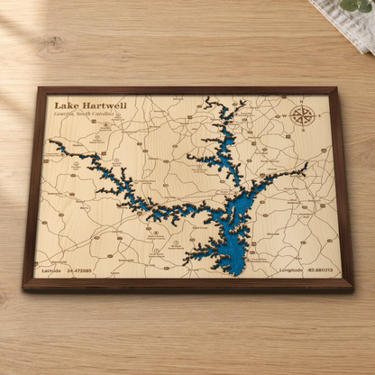 Lake Hartwell wood map lying flat on a wooden tabletop, showing the lake's long, winding arms and depth contours with Clemson, Anderson and Hartwell engraved in