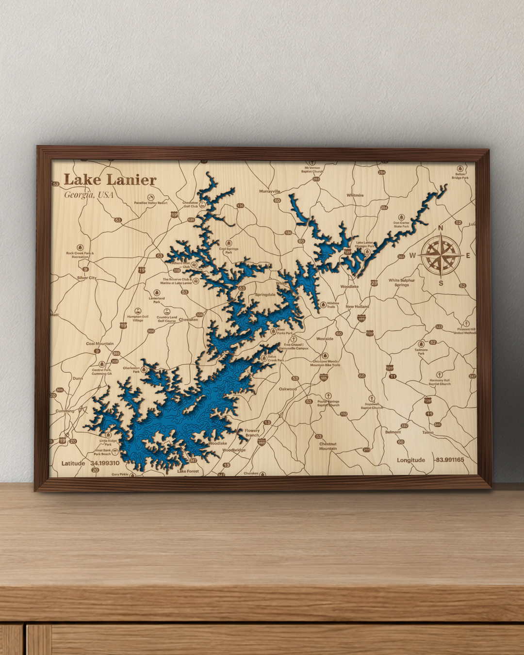 Lake Lanier wood map in a walnut frame standing on a wooden sideboard against a wall for scale