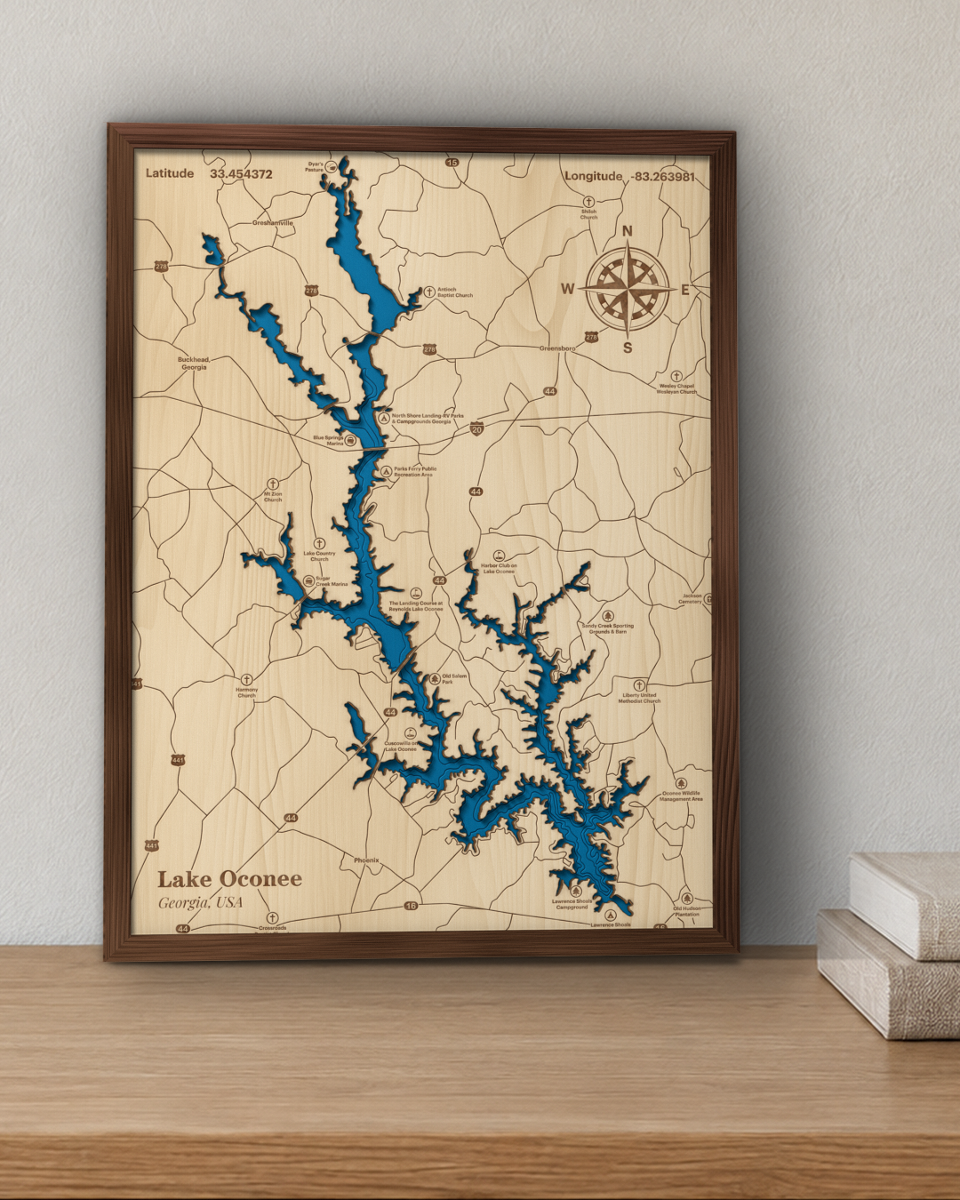 Lake Oconee wood map in a walnut frame standing on a wooden sideboard against a wall for scale