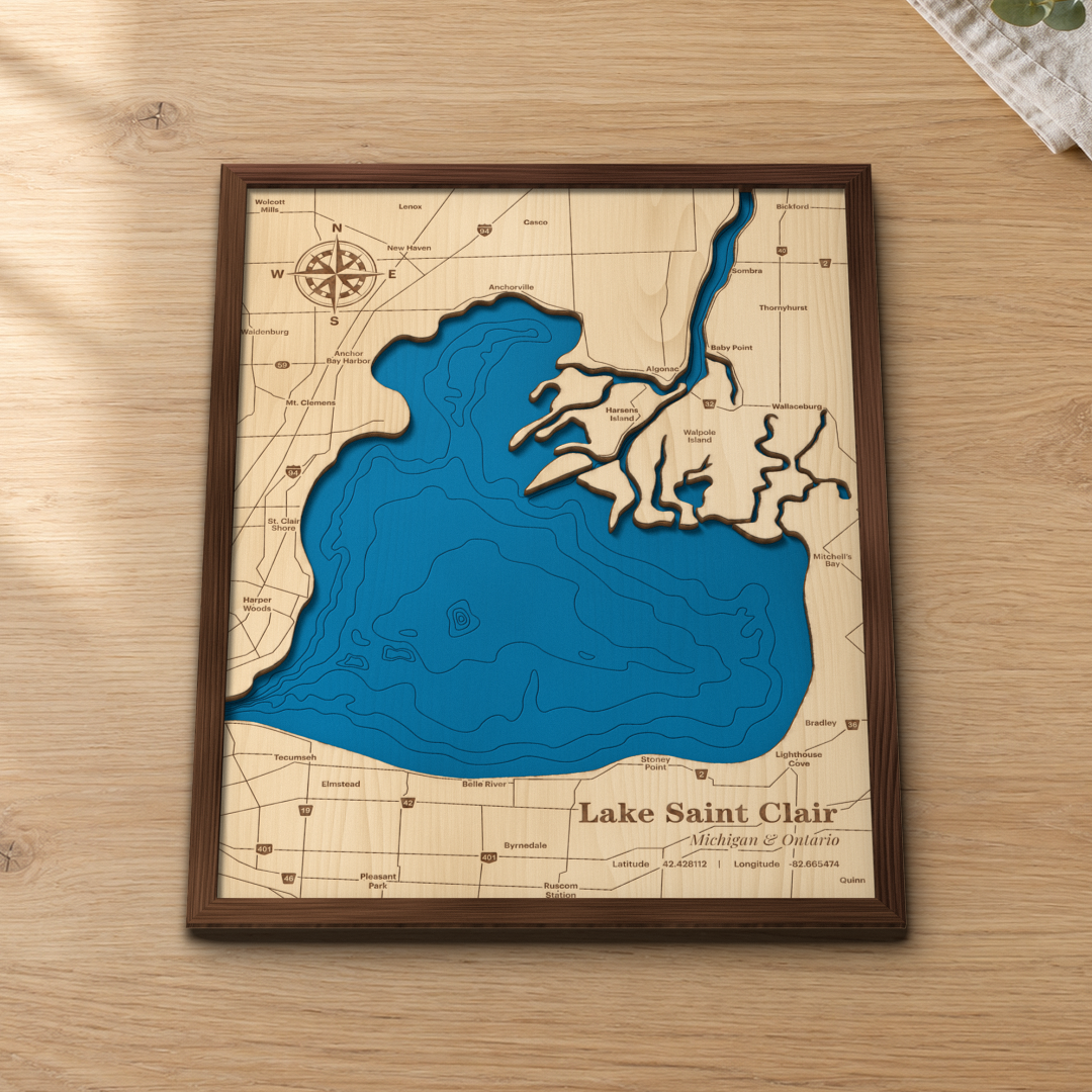 Lake Saint Clair wood map lying flat on a wooden tabletop, showing the depth contours, the St. Clair River delta with Harsens and Walpole Islands, and the Michigan and Ontario shore towns engraved in