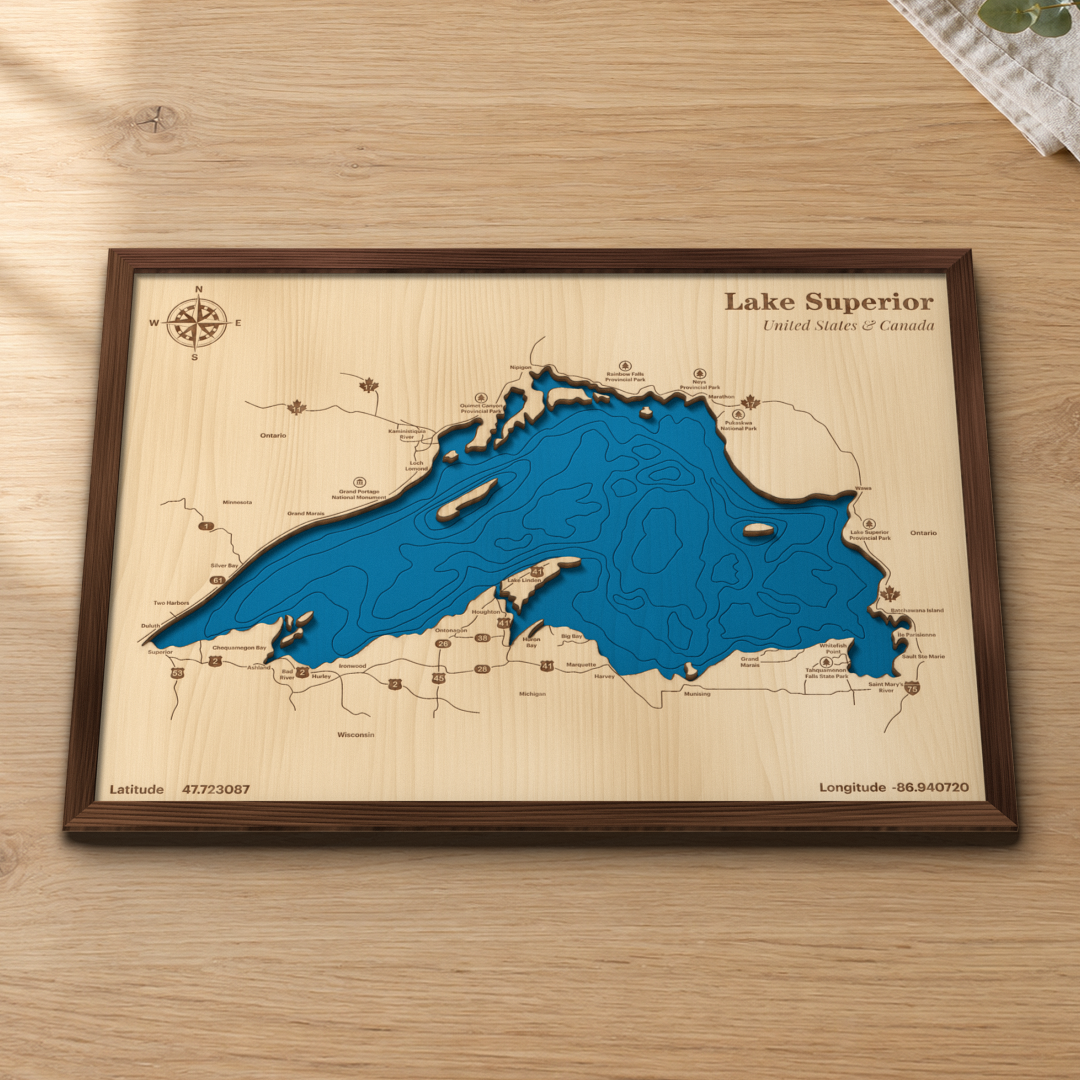 Lake Superior wood map lying flat on a wooden tabletop, showing the depth contours and the whole shoreline from Duluth to Sault Ste Marie engraved in