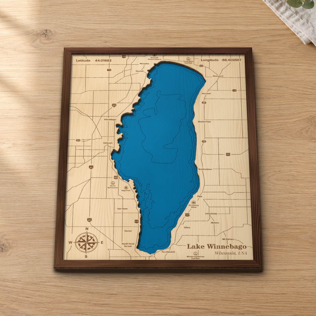 Lake Winnebago wood map lying flat on a wooden tabletop, showing the depth contours and the whole shoreline from Neenah to Fond du Lac engraved in