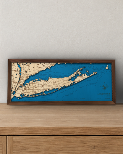 Long Island wood map in a walnut frame standing on a wooden sideboard against a wall for scale
