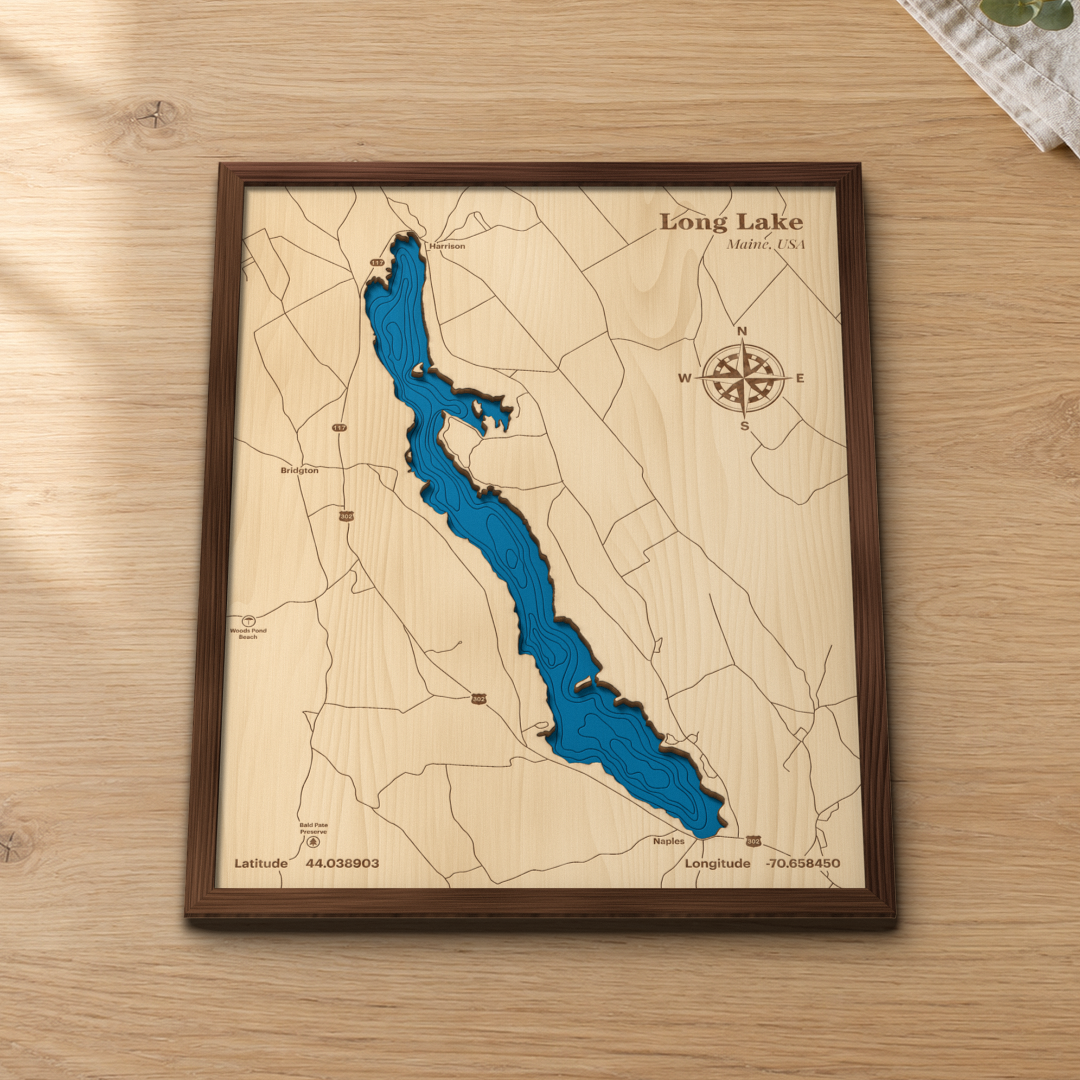 Long Lake wood map lying flat on a wooden tabletop, showing the long, narrow lake's depth contours with Harrison, Bridgton and Naples