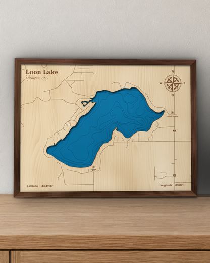 Loon Lake wood map in a walnut frame standing on a wooden sideboard against a wall for scale