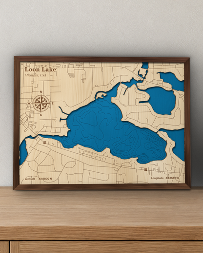 Loon Lake wood map in a walnut frame standing on a wooden sideboard against a wall for scale