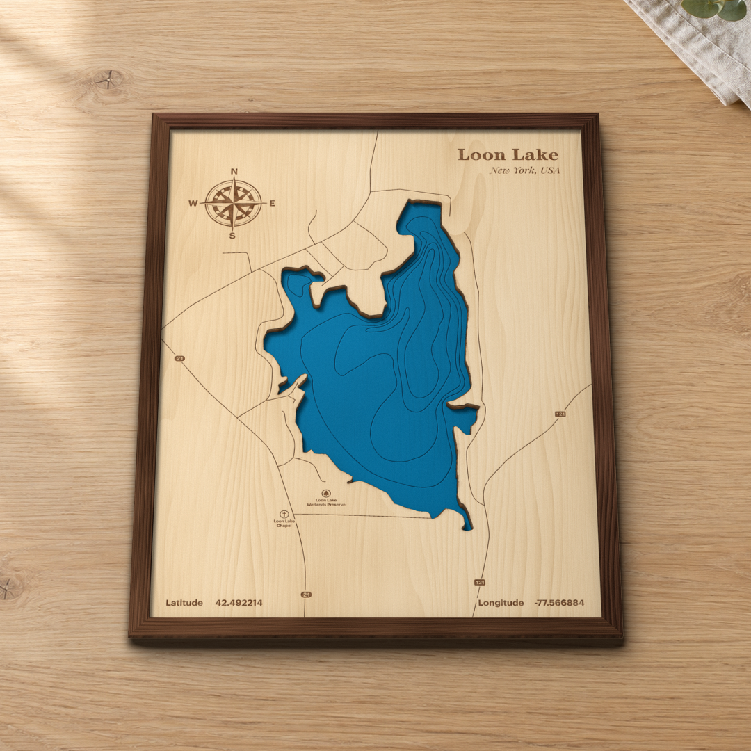 Loon Lake wood map lying flat on a wooden tabletop, showing the lake's depth contours and Routes 21 and 121