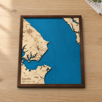 Lusby wood map lying flat on a wooden tabletop, showing the bay's depth contours with Lusby, Cove Point, Calvert Cliffs State Park and the Patuxent River engraved in