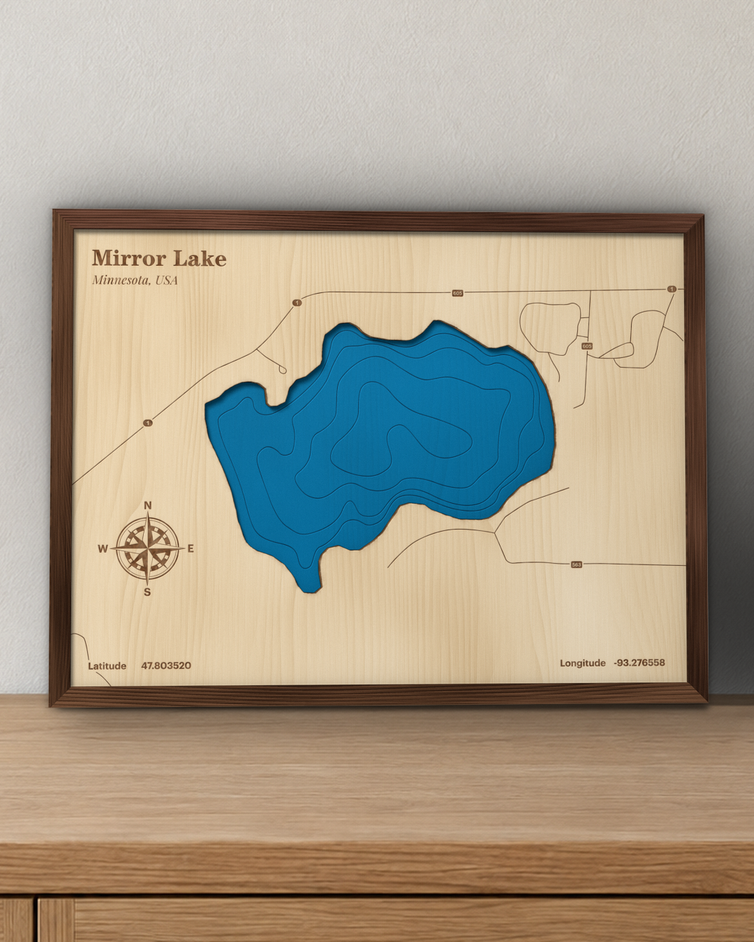 Mirror Lake wood map in a walnut frame standing on a wooden sideboard against a wall for scale