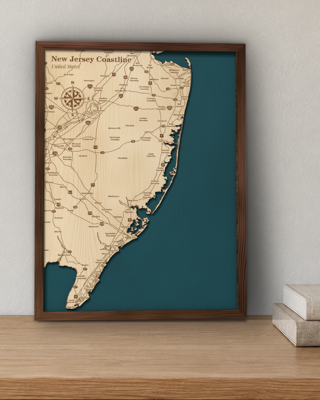 New Jersey Coastline wood map in a walnut frame standing on a wooden sideboard against a wall for scale