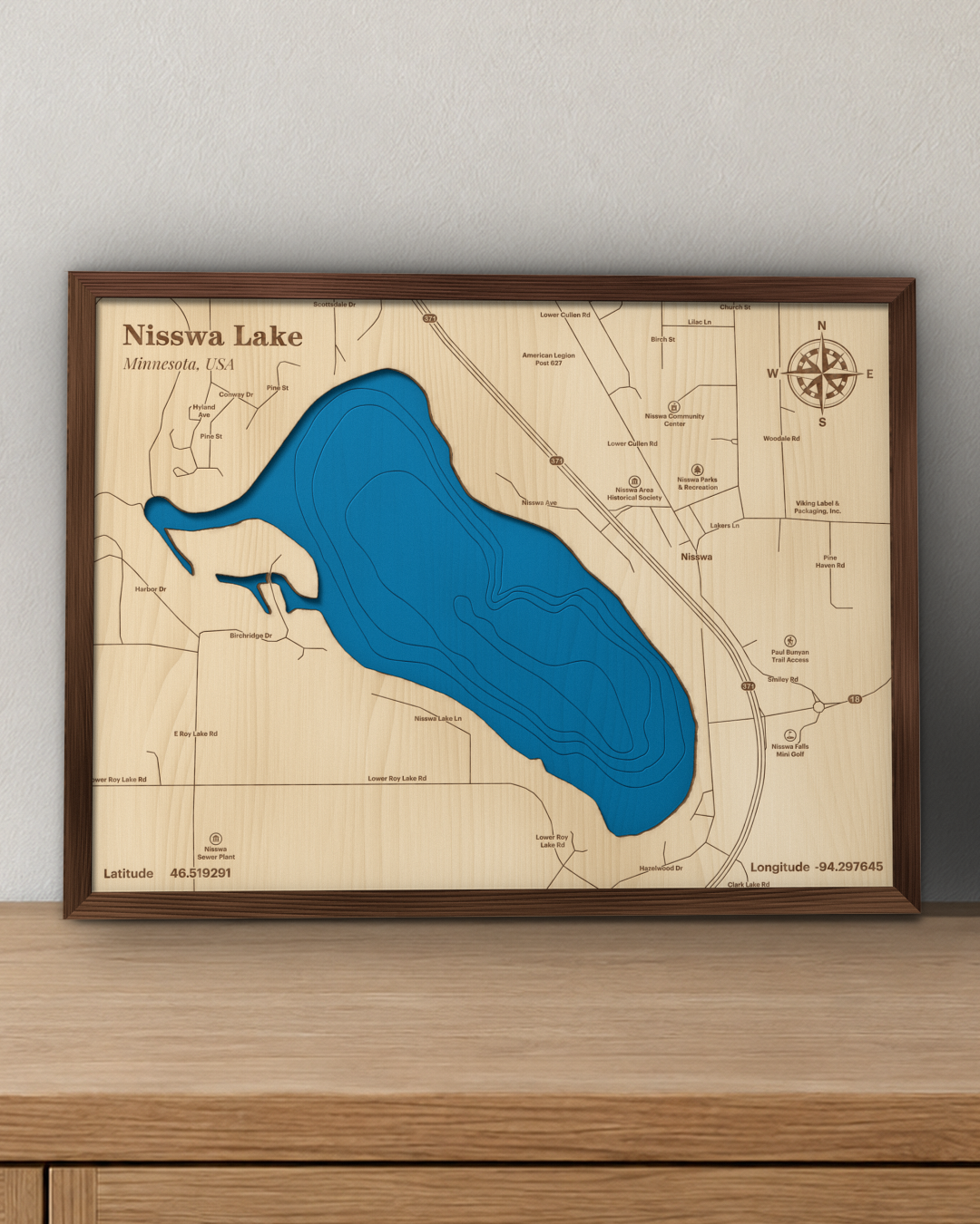 Nisswa Lake wood map in a walnut frame standing on a wooden sideboard against a wall for scale
