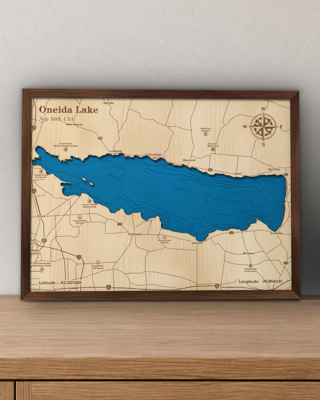 Oneida Lake wood map in a walnut frame standing on a wooden sideboard against a wall for scale