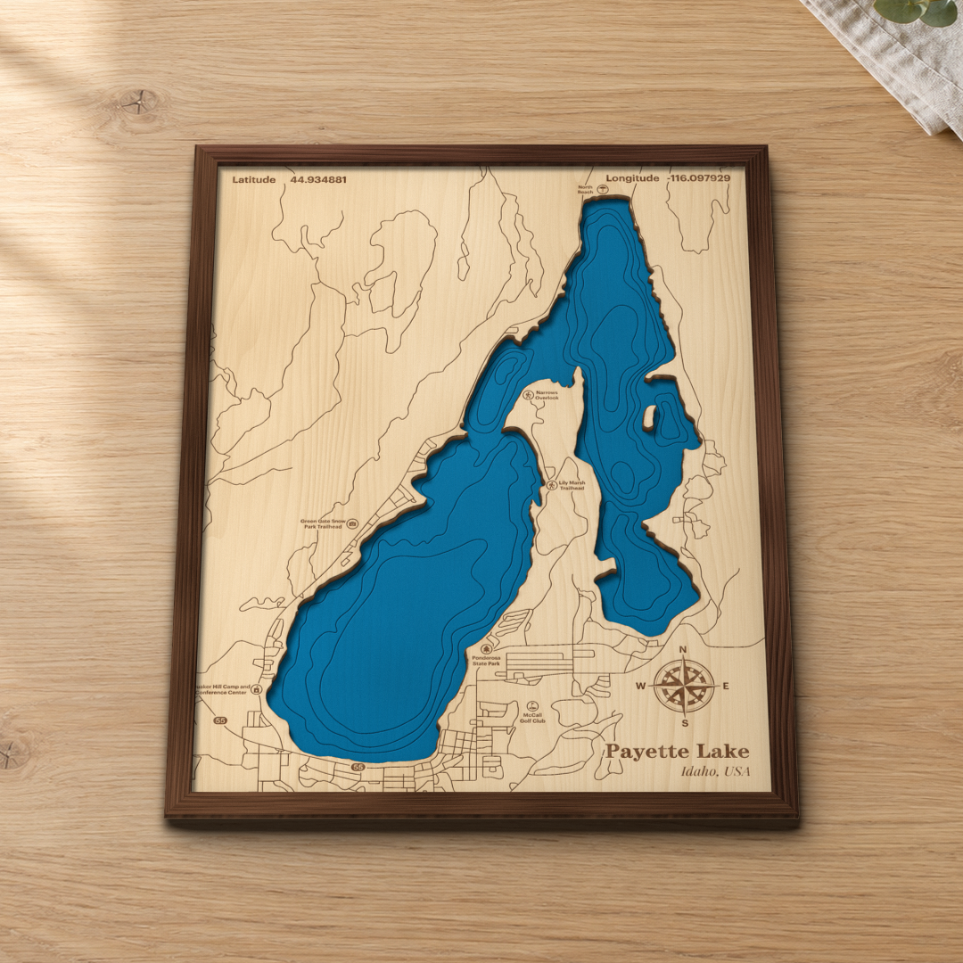 Payette Lake wood map lying flat on a wooden tabletop, showing the lake's depth contours with Ponderosa State Park, North Beach and the trailheads engraved in