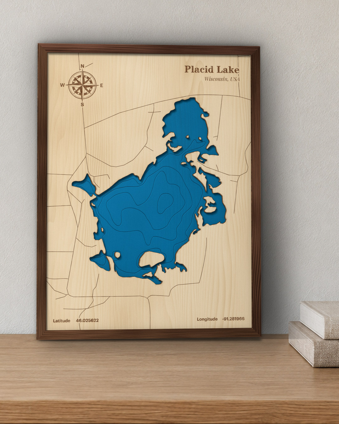 Placid Lake wood map in a walnut frame standing on a wooden sideboard against a wall for scale
