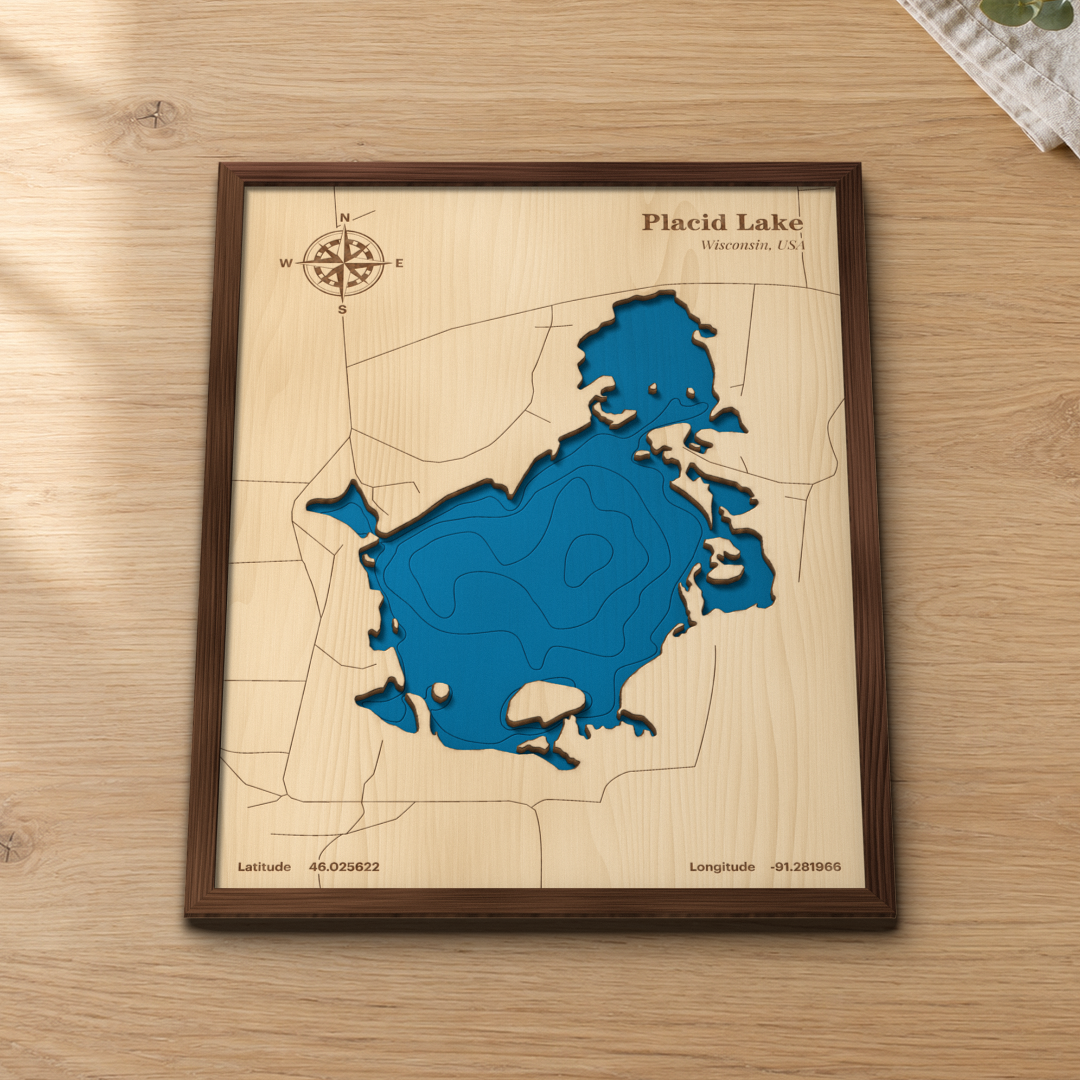 Placid Lake wood map lying flat on a wooden tabletop, showing the lake's bays, islands and depth contours