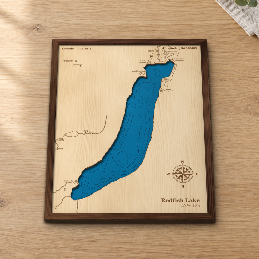Redfish Lake wood map lying flat on a wooden tabletop, showing the lake's depth contours with Redfish Lake Lodge, the campgrounds and trailheads engraved in