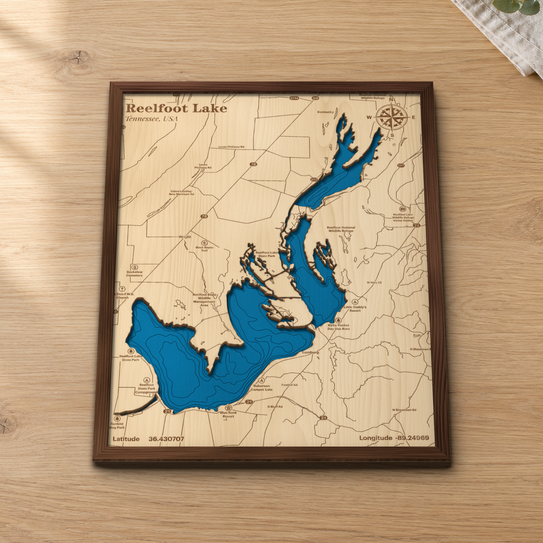 Reelfoot Lake wood map lying flat on a wooden tabletop, showing the lake's basins and depth contours with Samburg, Reelfoot Lake State Park and the wildlife refuge engraved in