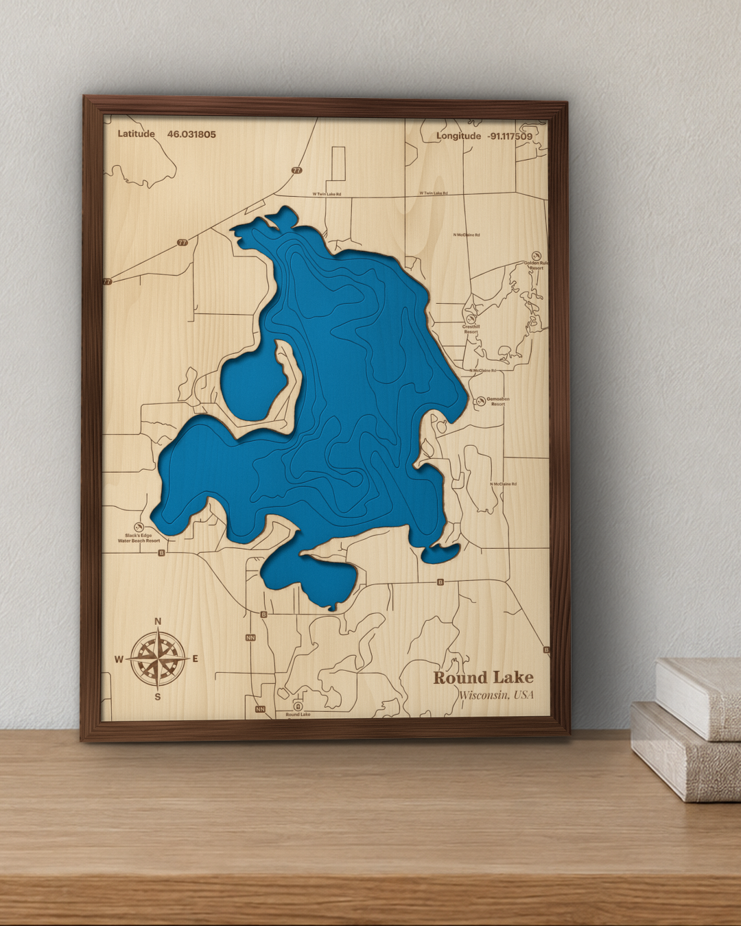 Round Lake wood map in a walnut frame standing on a wooden sideboard against a wall for scale