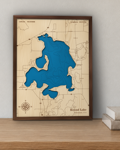 Round Lake wood map in a walnut frame standing on a wooden sideboard against a wall for scale