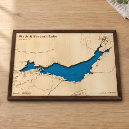 Sixth & Seventh Lake wood map lying flat on a wooden tabletop, showing Sixth and Seventh Lake's depth contours with Route 28, Inlet Golf Club and Eighth Lake Campground engraved in