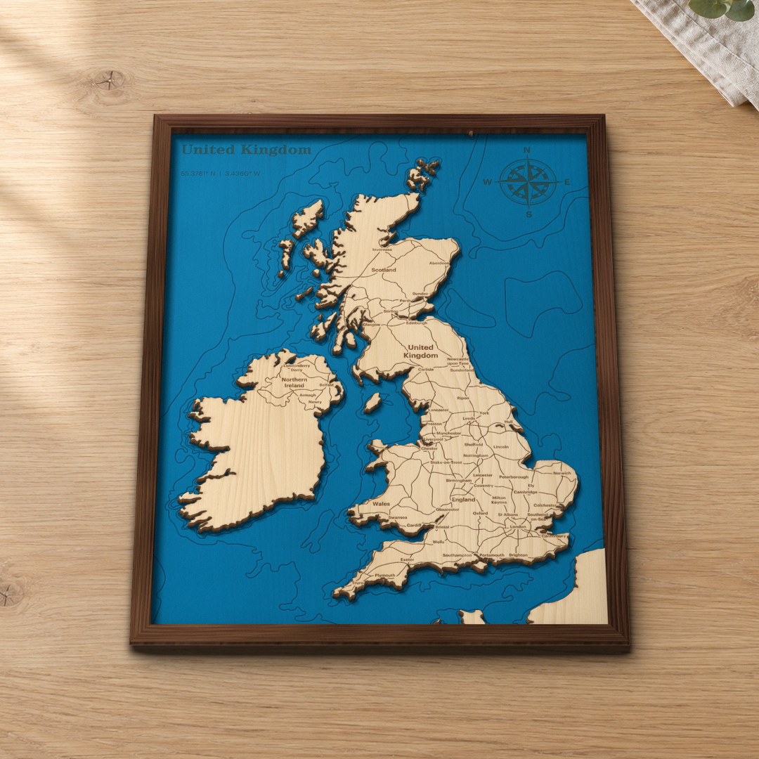 United Kingdom wood map lying flat on a wooden tabletop, showing the coastline and sea contours engraved in