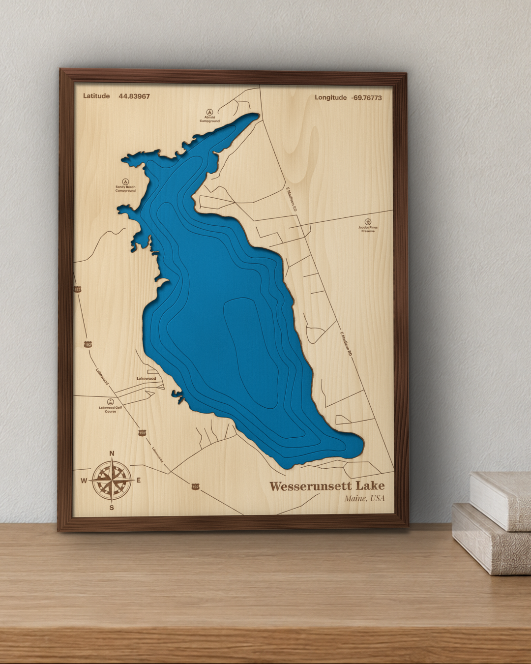 Wesserunsett Lake wood map in a walnut frame standing on a wooden sideboard against a wall for scale