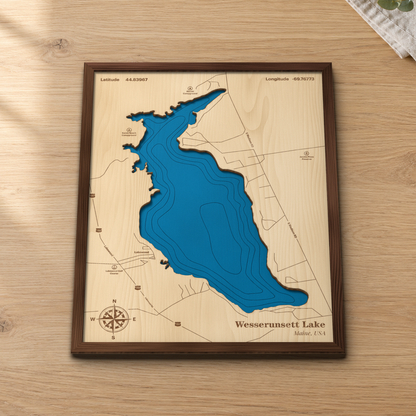 Wesserunsett Lake wood map lying flat on a wooden tabletop, showing the depth contours and the roads around the shore engraved in