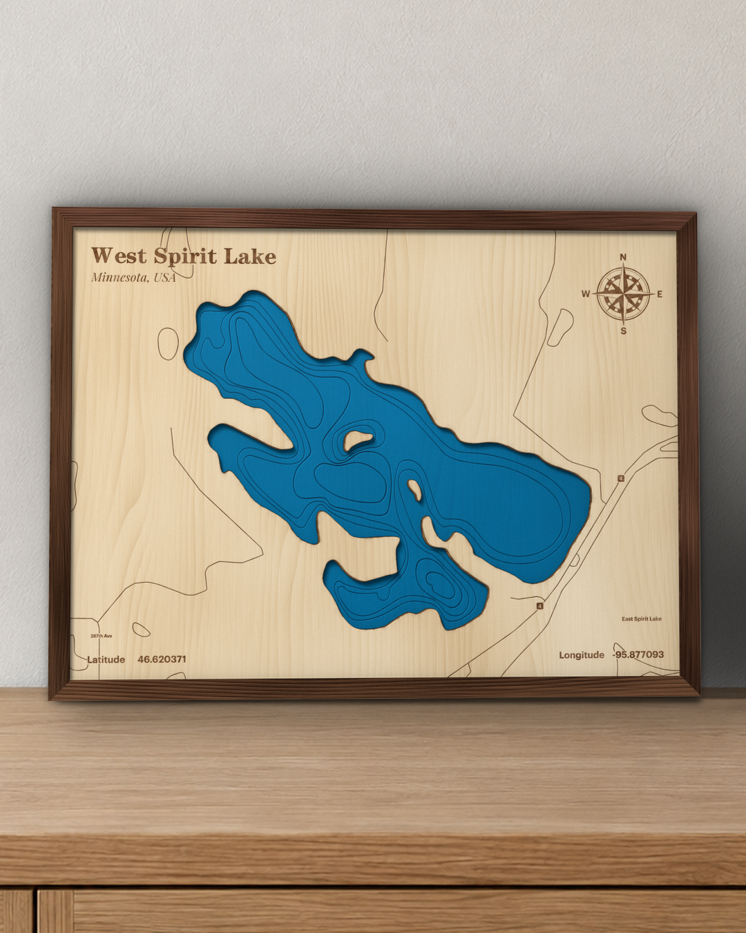 West Spirit Lake wood map in a walnut frame standing on a wooden sideboard against a wall for scale
